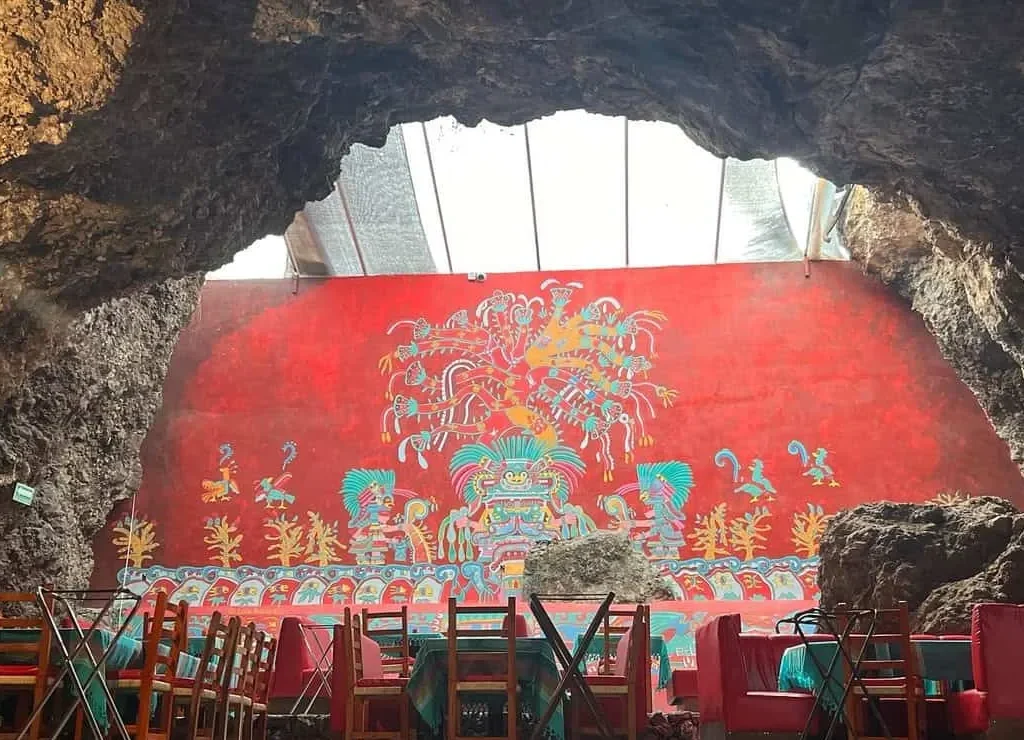 Un mural rojo de estilo teotihuacano preside el comedor del restaurante La Cueva en Teotihuacán